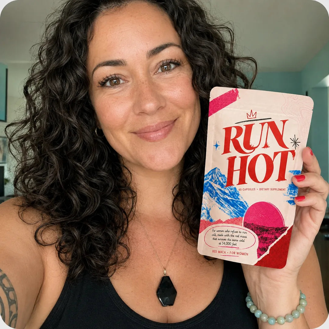 A smiling woman holding her Run Hot red maca pouch at home